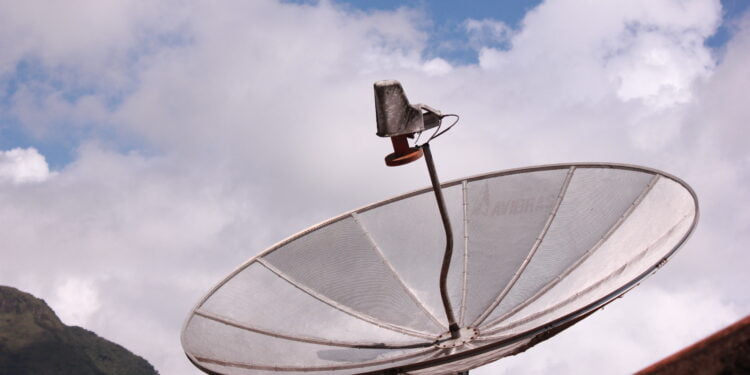 Satellite dish against blue sky and clouds